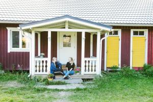 2 femmes assises sur la terrasse couverte d'une maison dans l'établissement Riihon Majatalo, à Riiho