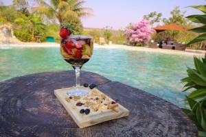 um copo de vinho numa mesa ao lado de uma piscina em Pousada Vereda da Serra em Pirenópolis