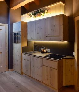 uma cozinha com armários de madeira e um lavatório em Al Bait Del Legn 5 em Bormio