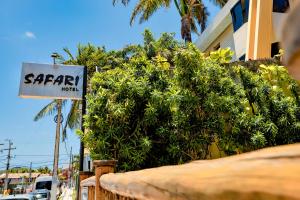 a sign for a saari hotel next to a bush at Safari Natal Beach Hotel in Natal