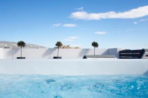 a pool with blue water in front of a white wall at The Loft Athens in Athens