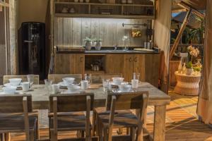 a wooden table with chairs and a sink in a kitchen at Frei wie der Wind-Glamping in Dierhagen