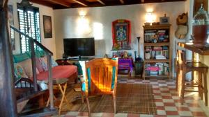 sala de estar con TV, mesa y sillas en Casa Vila Do Outeiro en Praia do Espelho