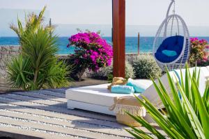 a patio with a couch and a swing and the ocean at Hotel Lava Beach in Puerto del Carmen