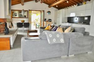 a living room with a gray couch and a kitchen at Villa Rosa in Cortona