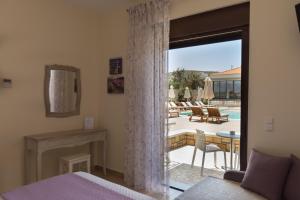 a bedroom with a door open to a patio with a pool at Elafonisos Resort in Elafonisos
