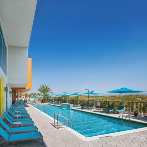 - une piscine dans un complexe avec des chaises et des parasols dans l'établissement Margaritaville Jacksonville Beach, à Jacksonville Beach