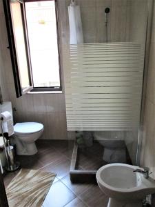 uma casa de banho com um chuveiro, um WC e uma janela. em Studio Emi em Pomorie