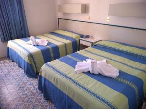 Habitación de hotel con 3 camas y toallas. en HOTEL OLIDEN, en Coatzacoalcos