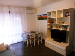 a living room with a dining room table and a television at Caletta Beach in Castiglioncello