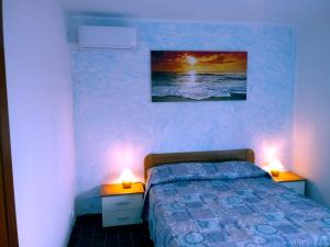 a bedroom with a bed and two night stands with lamps at Caletta Beach in Castiglioncello