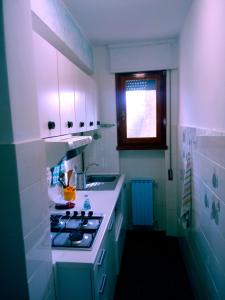 a white kitchen with a stove and a sink at Caletta Beach in Castiglioncello