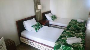 two beds in a hotel room with green and white at Nehir Dalyan Boutique Otel in Ortaca