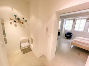 a white room with a bed and a chair at Lauben Suite Old Town Bolzano in Bolzano