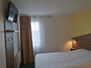 um quarto de hotel com uma cama e uma televisão em FASTHOTEL PARIS OUEST BOUAFLE em Bouafle