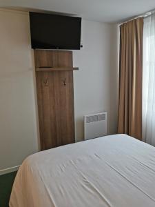 een slaapkamer met een bed en een flatscreen-tv bij FASTHOTEL PARIS OUEST BOUAFLE in Bouafle