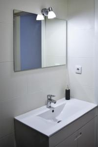 ポンタ・デルガダにあるOcean Blue Apartmentの白い洗面台と鏡のあるバスルーム +5枚の写真