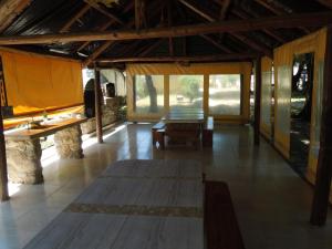 サンタ・ロサ・デ・カラムチタにあるCabañas La Pircaのテーブルのあるリビングルームと窓のある部屋