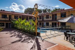 a building with a pool and a clock in a courtyard at Hotel Vanguardia Natural in Villavicencio
