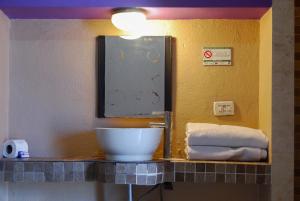 a bathroom with a sink and a mirror and towels at Hotel Platino in Monterrey