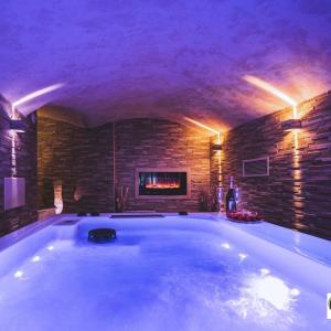 bañera grande en una habitación con chimenea en CHAPLIN Luxury Holiday House, en Viterbo