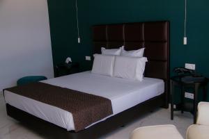 a bedroom with a large bed with a brown headboard at Hotel Por Do Sol in Tarrafal