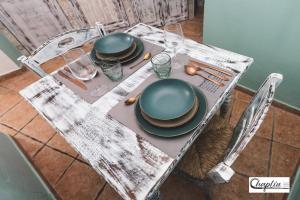 una mesa con platos y utensilios. en CHAPLIN Luxury Holiday House en Viterbo