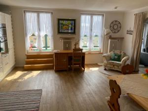 a living room with a desk and some windows at Ferienwohnung Giacomelli 1 in Rottach-Egern