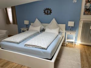 ein Schlafzimmer mit einem weißen Bett mit blauen Wänden in der Unterkunft Ferienwohnung Giacomelli 1 in Rottach-Egern