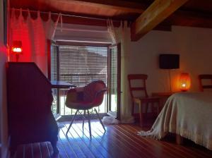 ein Schlafzimmer mit einem Bett, einem Tisch und einem Stuhl in der Unterkunft El Baciyelmo in Trujillo