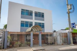 a white building with a gate in front of it at Hotel Ayenda Puerto Vigia 1807 in Cartagena de Indias