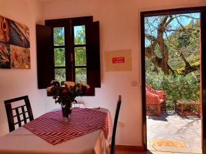 eine Vase mit Blumen auf einem Tisch in einem Zimmer in der Unterkunft Cantinho Rural in Camacha