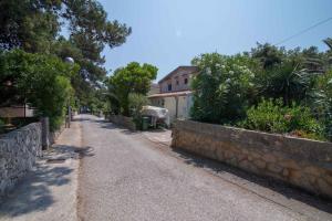 een lege straat met een huis en bomen bij Studio in Mali Losinj 36584 in Mali Lošinj