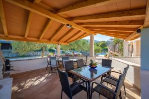 a patio with a table and chairs under a wooden pergola at Apartment Drenje 3 in Drenje