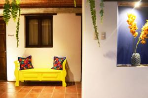 twee kussens op een gele bank in een kamer bij Hotel Luna Maya Antigua in Antigua Guatemala
