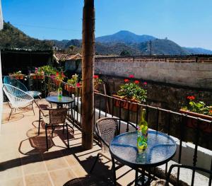 two tables and chairs on a balcony with a view at Luna Maya Antigua in Antigua Guatemala
