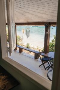 una ventana con vistas a la playa desde una casa en Bonito Paraiso Ilha Grande en Ilha Grande