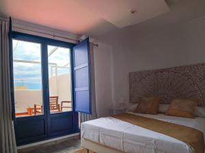 a bedroom with a bed and a large glass door at Knysna Boutique Rooms in Peniscola
