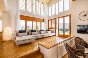 sala de estar con sofá, sillas y ventanas en Casa Mirestany- Wonderful house with amazing views, en Banyoles