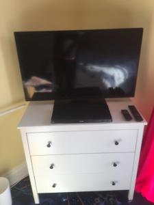 TV a/nebo společenská místnost v ubytování PINK HOUSE ,Opposite Beach ,SLEEPS 6 , 2 BEDROOM GROUND FLOOR SELF CONTAINED GARDEN FLAT , PRIVATE ENTRANCE , KITCHEN , Guaranteed Parking ,Wifi , Movies ,Bathroom ,fridge , microwave ,BEDROOM 1, DOUBLE BED & 2 SINGLE BEDS ,BEDROOM 2 , DOUBLE BED