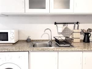 eine Küchentheke mit einer Spüle und einer Mikrowelle in der Unterkunft Riverside Apartment 42 - Lisbon in Lissabon