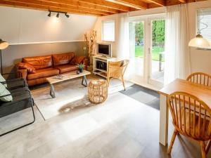 uma sala de estar com um sofá e uma mesa em Modern Holiday Home in Friesland by the Lake em Anjum