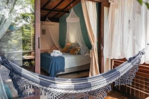 een slaapkamer met een hangmat in een kamer met een bed bij Bonito Paraiso Ilha Grande in Abraão