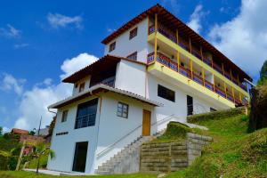 a white building on top of a hill at Roble Colonial - Apartahotel en Guatapé in Guatapé