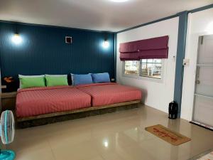 a bedroom with a bed with a blue wall at Pran sea & sun 2 in Pran Buri