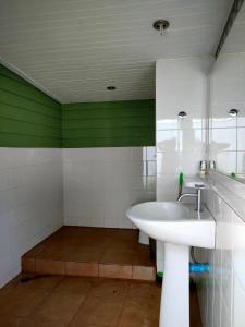 a bathroom with a sink and a green wall at Pran sea & sun 2 in Pran Buri