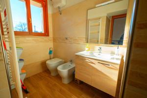 La salle de bains est pourvue d'un lavabo, de toilettes et d'un miroir. dans l'établissement Casetta di Pietra, à Gavorrano