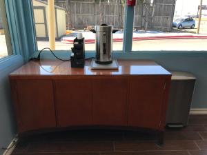 a coffee maker sitting on top of a table in front of a window at Budget Inn & Suites in Amarillo