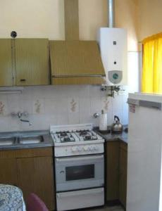 a kitchen with a white stove and a sink at La Luisa in Merlo