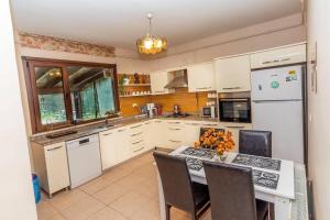 a kitchen with white cabinets and a table with chairs at MyHomeSapanca in Sapanca
